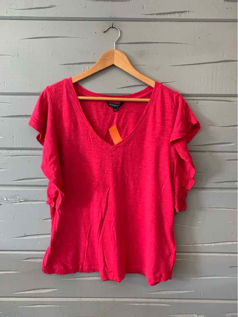 Bright pink short-sleeve blouse with ruffled sleeves and a V-neckline, hanging on wooden hanger.