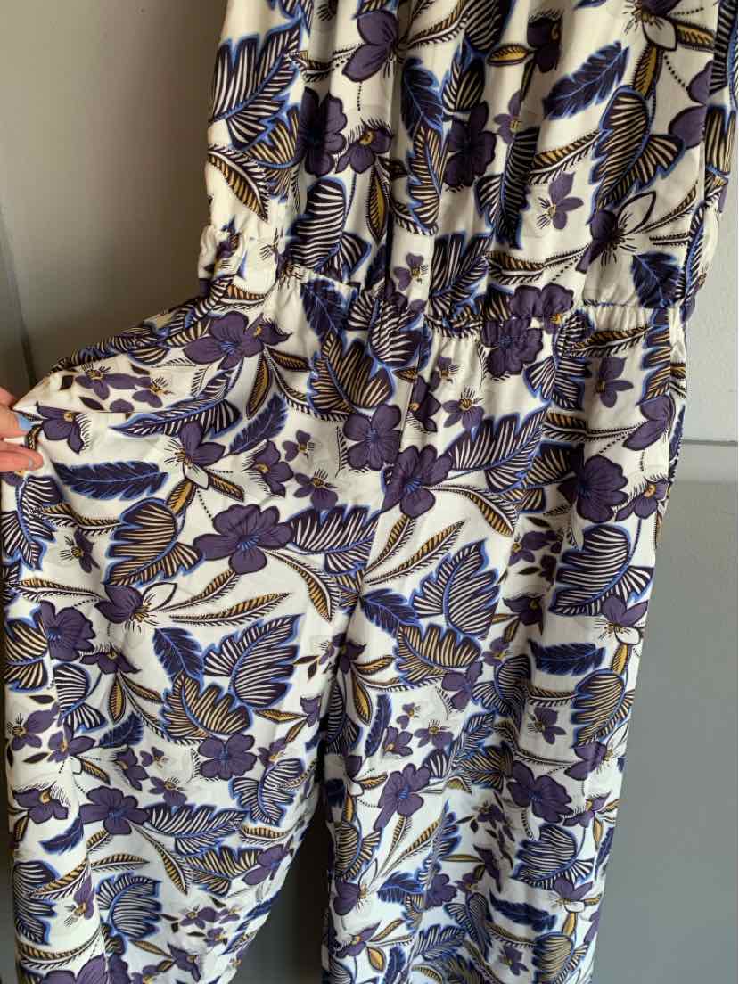 White fabric with a blue and purple floral print, gathered waistline, lightweight flowy material dress.