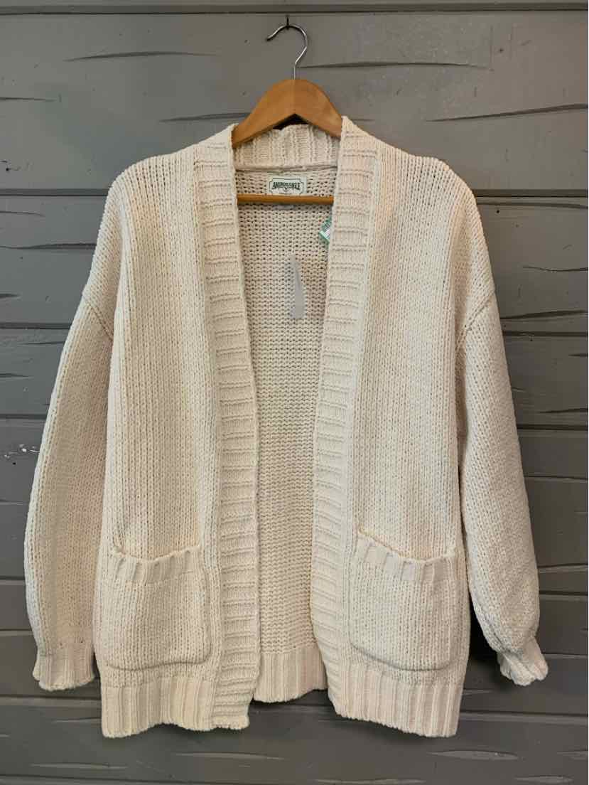 Cream-colored open-front knitted cardigan with long sleeves and front pockets, size XS.
