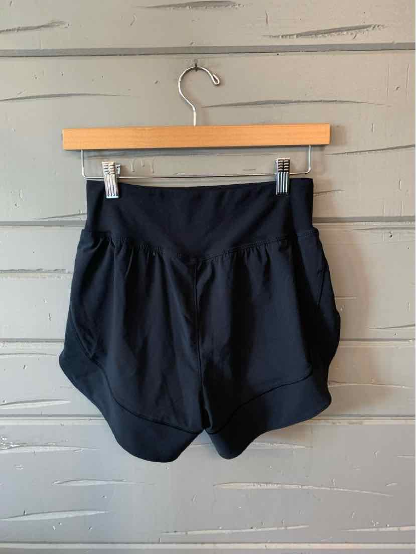 Black Under Armour women's athletic shorts with wide elastic waistband and layered curved hem.