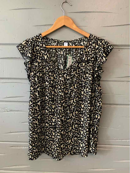 Black and white animal print blouse with short sleeves and gathered neckline on wooden hanger.