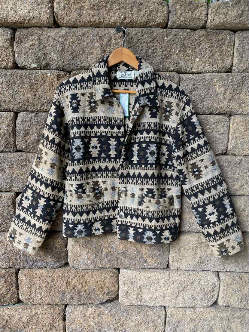 Black and beige Aztec pattern zip-up jacket with collar, elastic cuffs, and front pockets.