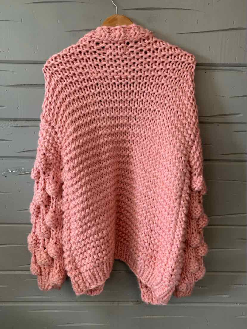 Chunky knit dusty pink cardigan with oversized bobble sleeves and open front design.