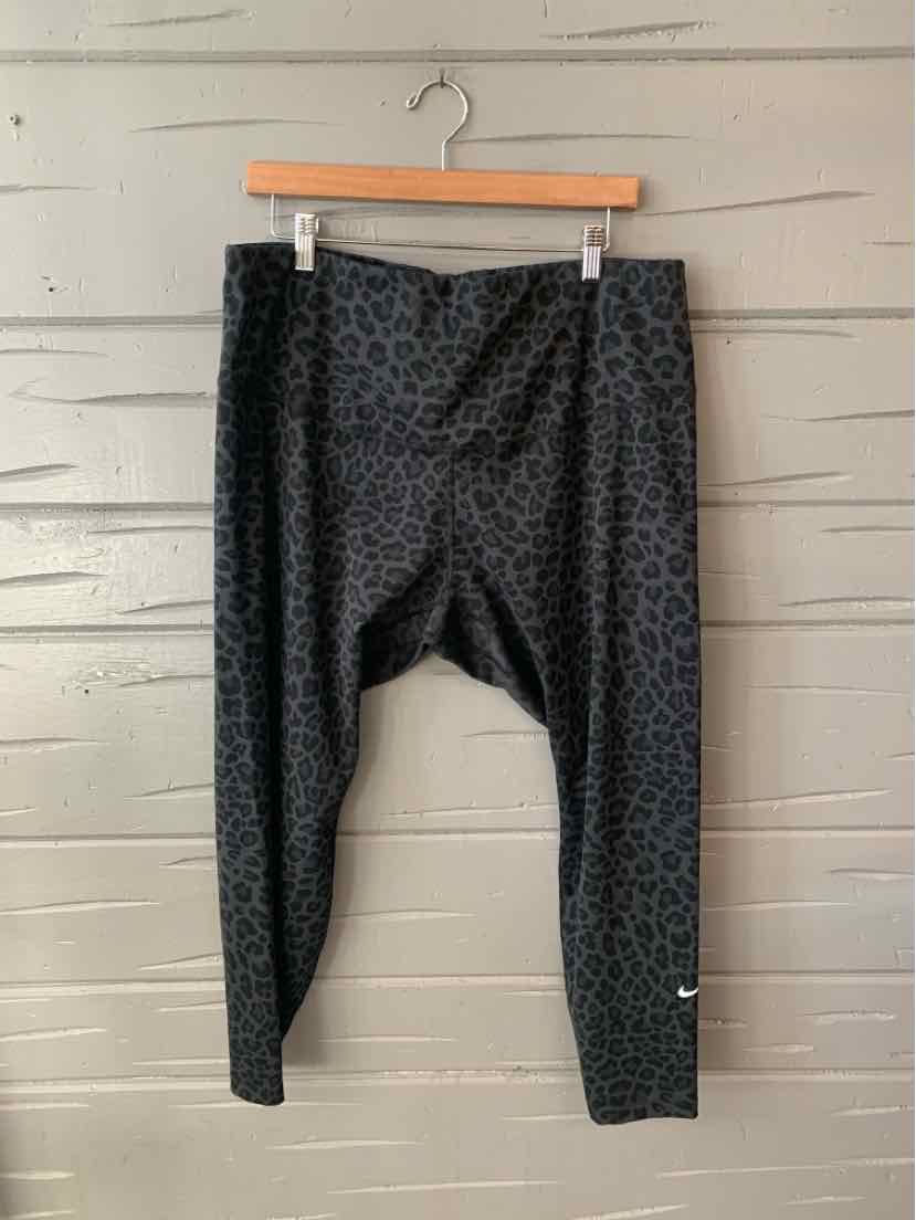 Black Nike leggings with subtle cheetah print and small white Nike swoosh on lower leg.