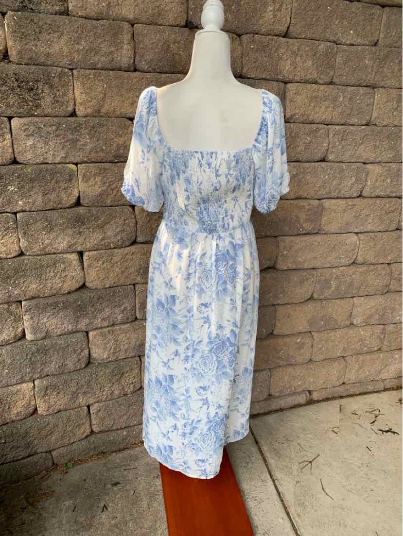 Light blue and white floral patterned midi dress with puff sleeves and square neckline on mannequin.