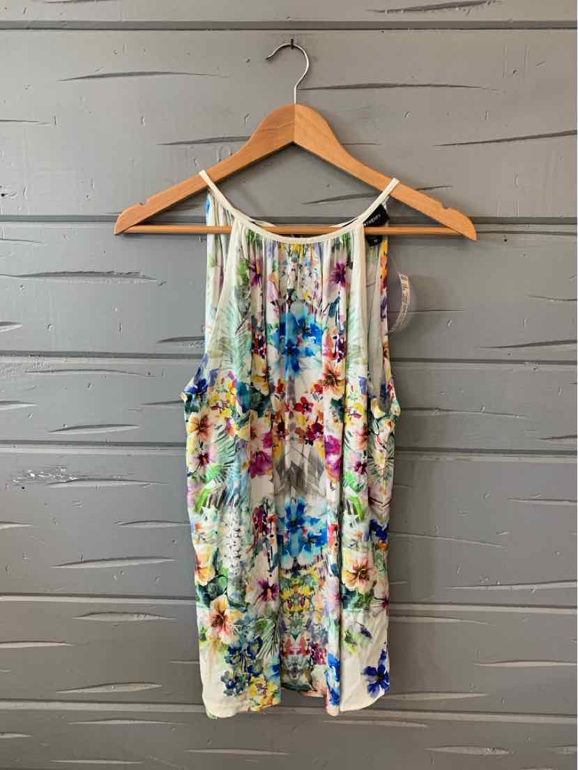 Sleeveless floral dress in multicolor with thin straps and relaxed fit, hanging on wooden hanger.
