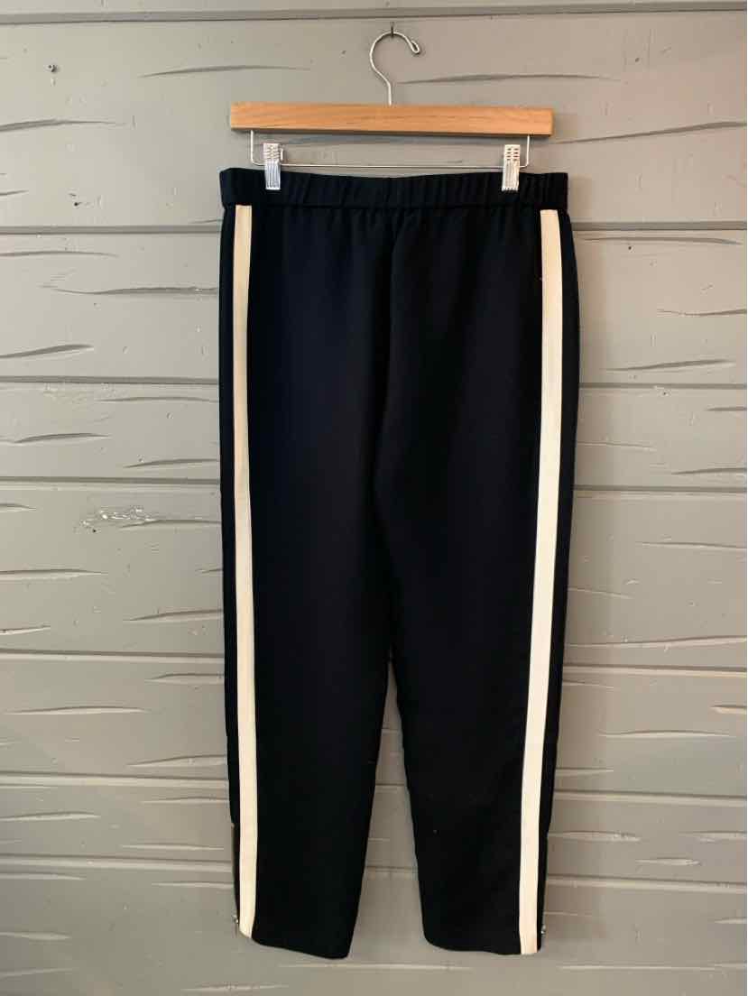 Black slim-fit pants with white side stripes and elastic waistband hanging on wooden hanger.