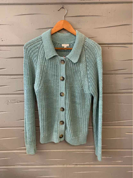 Light blue button-up knit cardigan with ribbed texture and collar on wooden hanger.