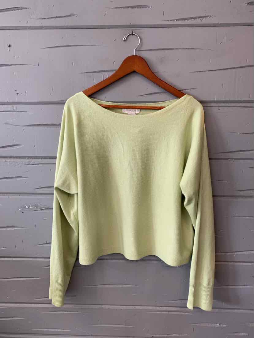 Light green long-sleeve knit sweater with boat neckline and relaxed fit hanging on wooden hanger.
