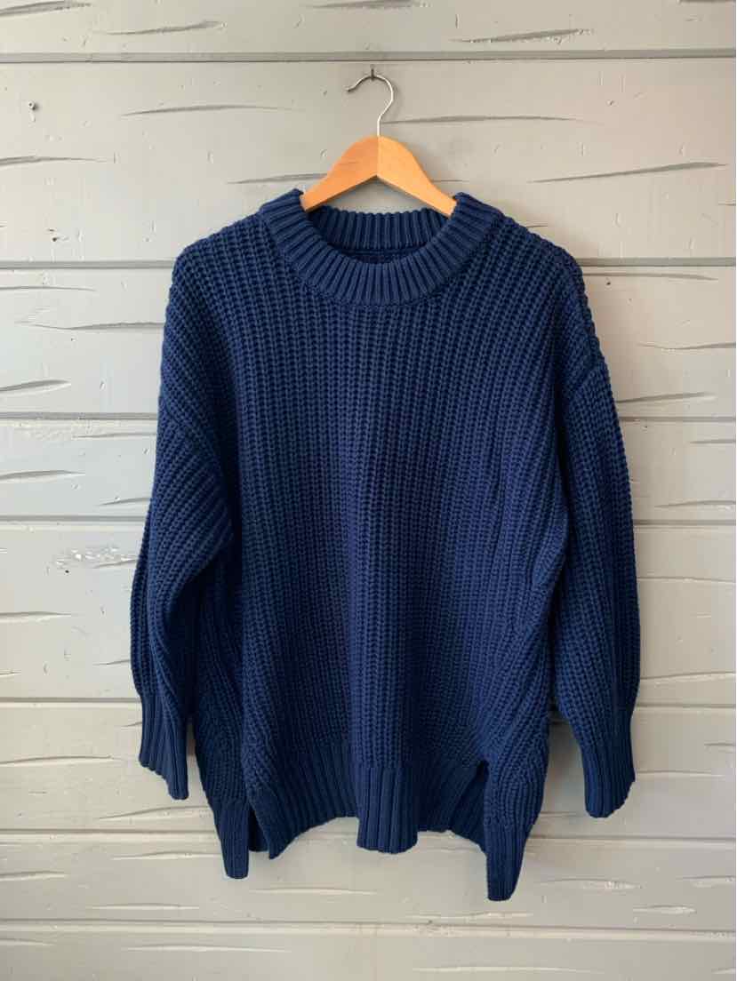 Navy blue ribbed knit sweater with a crew neck, long sleeves, and a relaxed fit on a hanger.