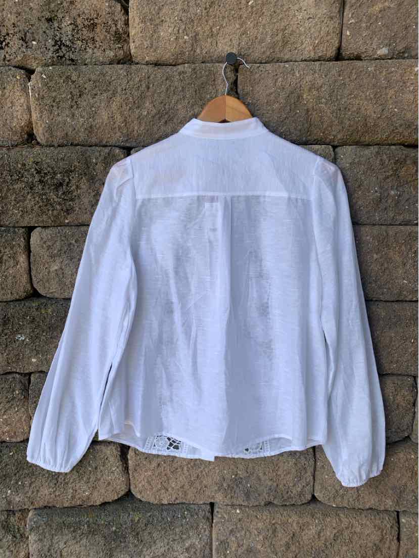 White long-sleeve blouse with lace details, buttoned cuffs, and a back pleat, medium size.