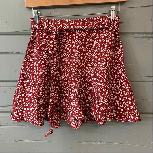 Red floral print mini skirt with ruffled hem and adjustable waist tie.