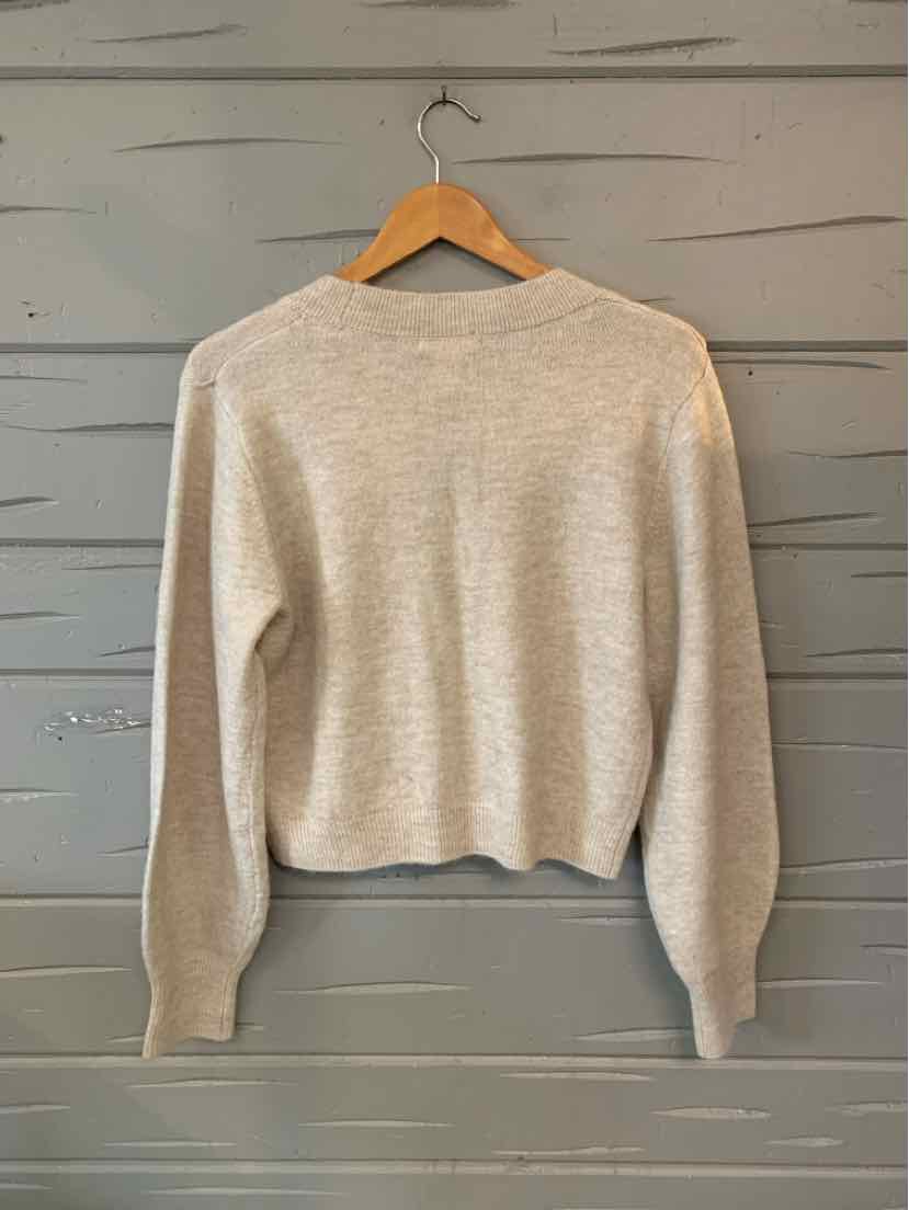 Oatmeal-colored H&M knit sweater with a crew neckline, long sleeves, and ribbed cuffs and hem.