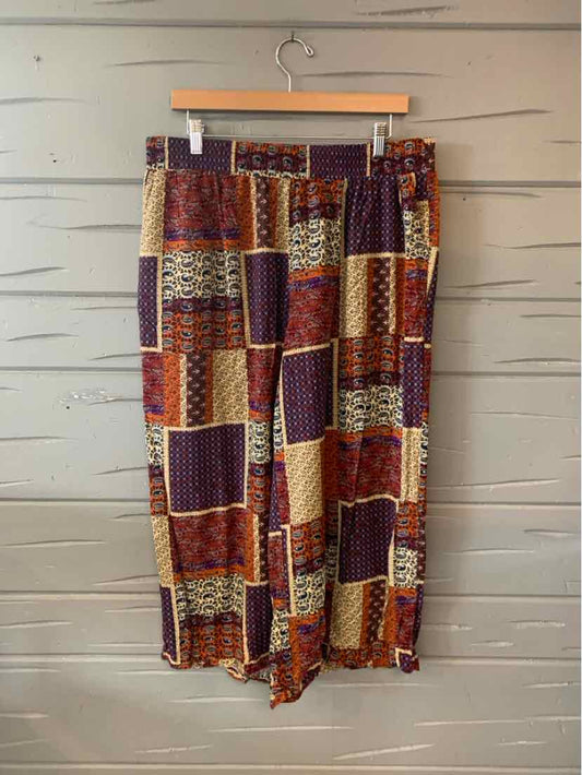 Wide-leg pants with burgundy, beige, and brown patchwork pattern on lightweight fabric.