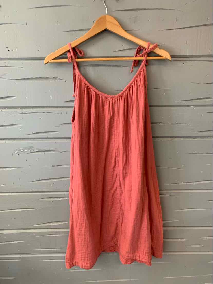 Brick red sleeveless dress with tie straps and a relaxed fit on a wooden hanger.