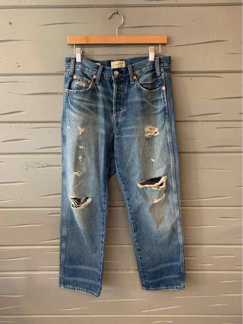 Blue distressed denim jeans with multiple rips and frayed details, straight-leg fit.