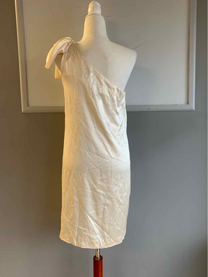 Ivory one-shoulder silk dress with bow detail on shoulder, knee-length silhouette.