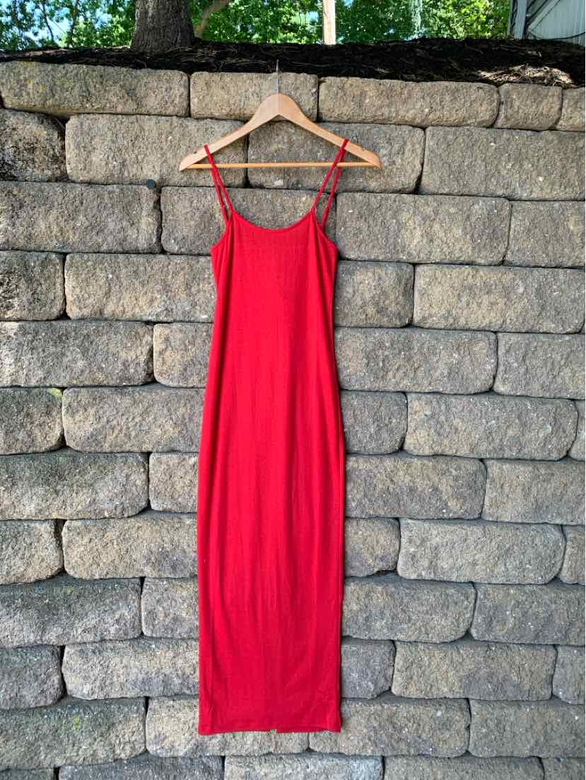 Red sleeveless midi dress with thin straps and a straight silhouette on wooden hanger.