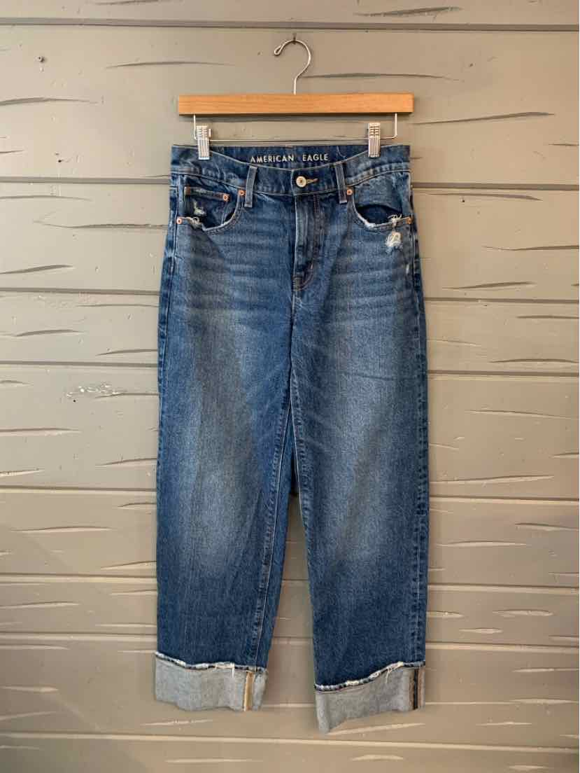 Blue denim high-waisted jeans with cuffed hems and classic five-pocket design.