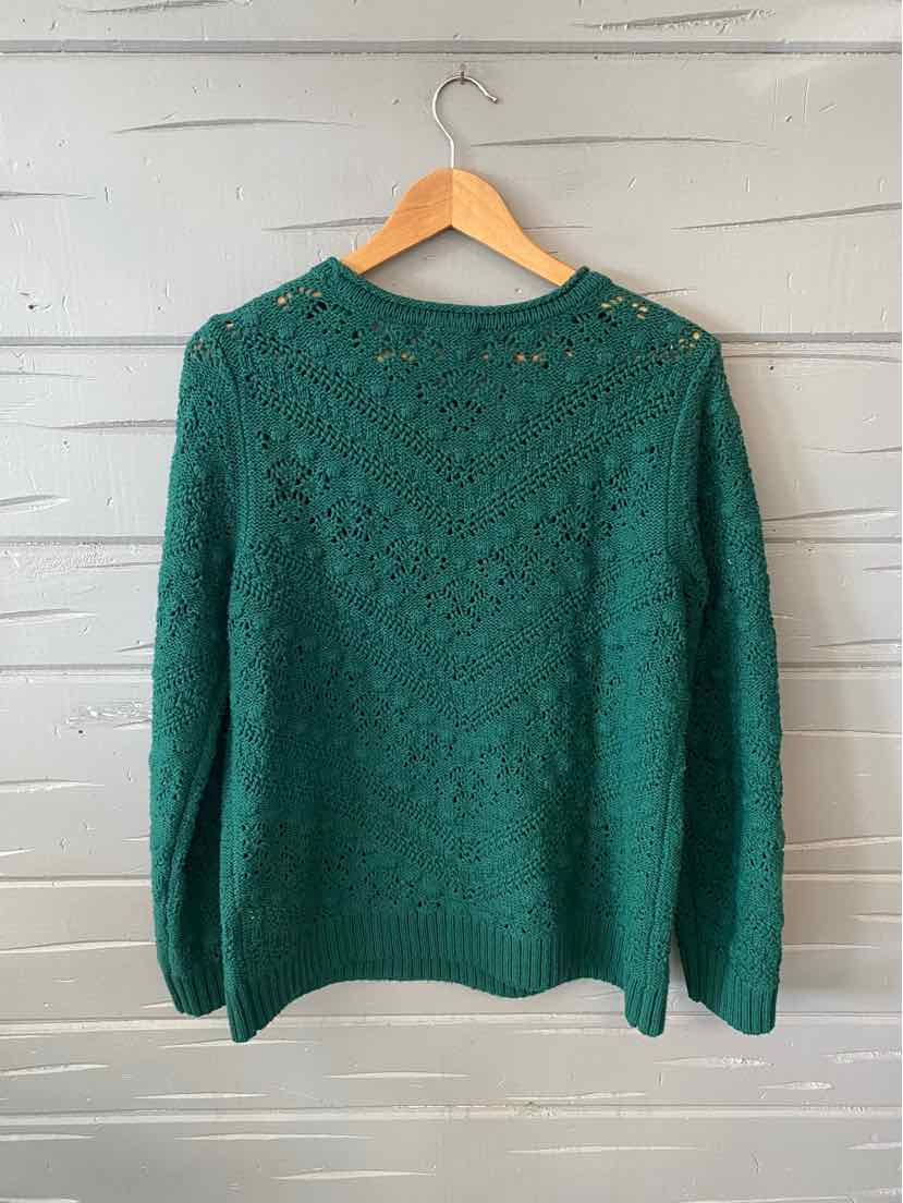 Green knit sweater with textured chevron pattern and long sleeves on wooden hanger.