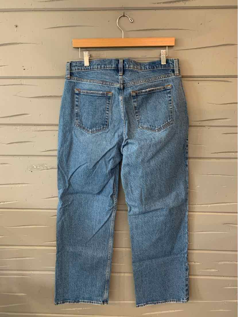 Light blue denim jeans with straight legs, five-pocket design, and frayed hems hanging on a wooden hanger.