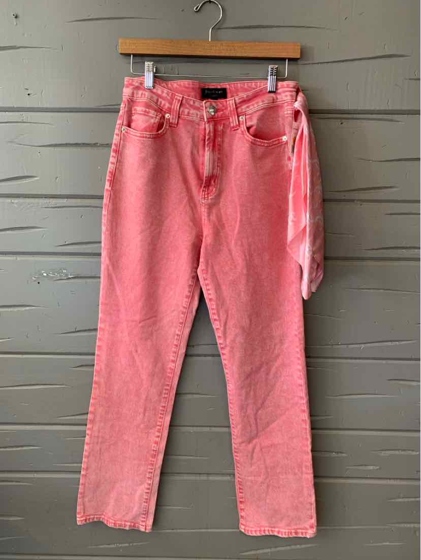 Pink denim straight-leg pants with classic five-pocket design and belt loops hanging on wooden hanger.