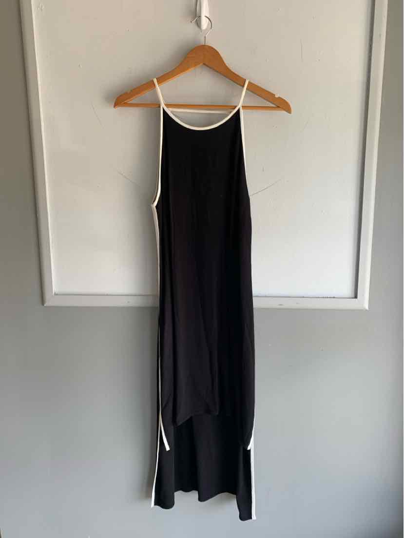 Black sleeveless slip dress with white trim along thin straps and side seams, midi length with curved hem.