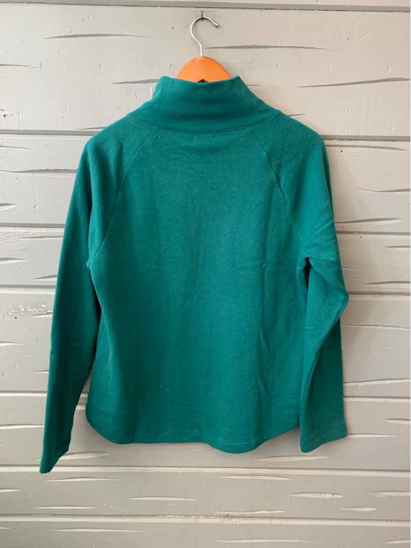Teal green long-sleeve crew neck top with relaxed fit, displayed on wooden hanger against white slatted wall.