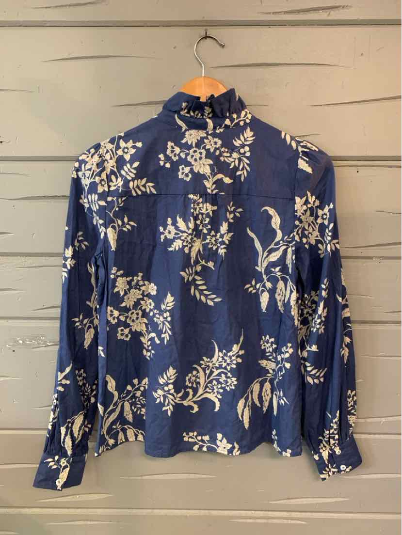 Navy blue long-sleeve blouse with a high ruffled neckline and cream floral print.