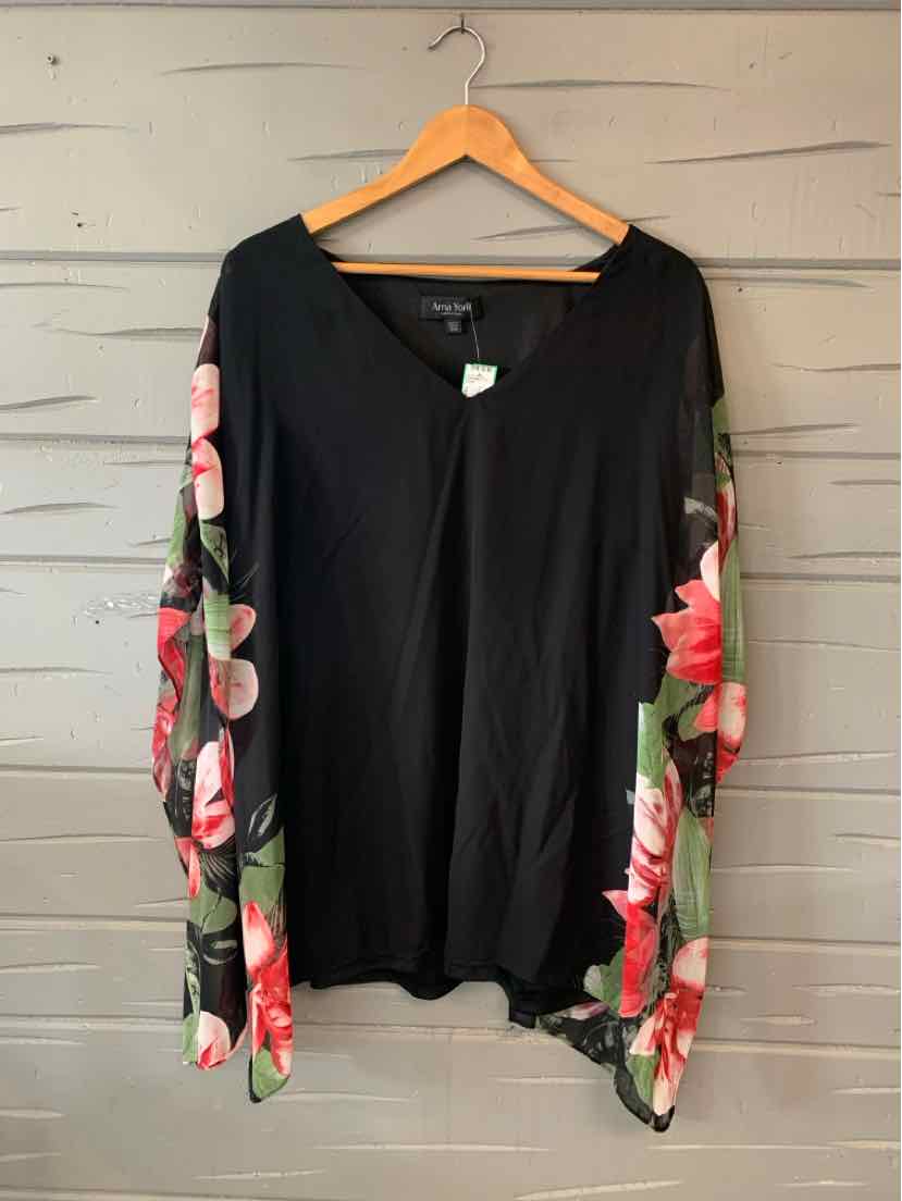 Black long-sleeve top with pink floral patterned sleeves hanging on wooden hanger.