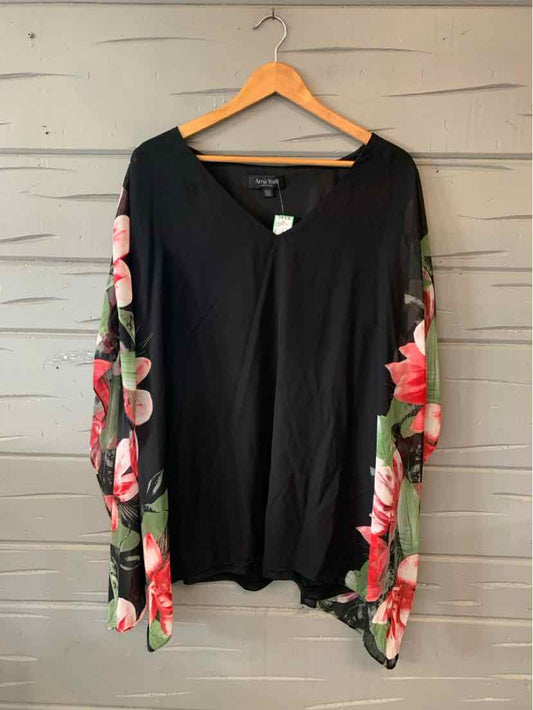 Black long-sleeve top with pink floral patterned sleeves hanging on wooden hanger.