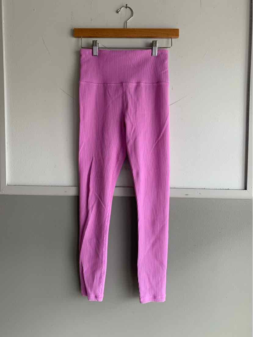 Pink ribbed high-waist leggings with seam details, size small, hanging on wooden hanger.