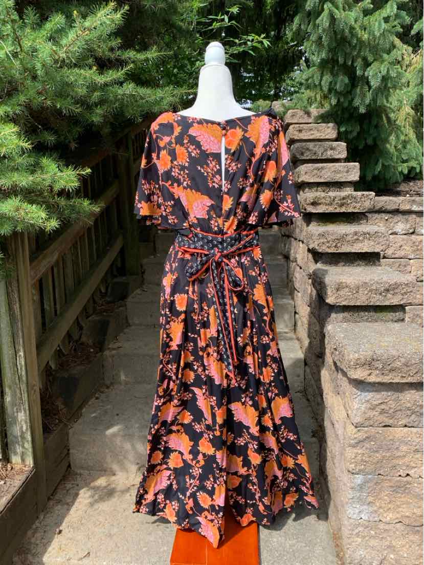 Black floral midi dress with orange flower patterns, short sleeves, and a cinched waist belt.