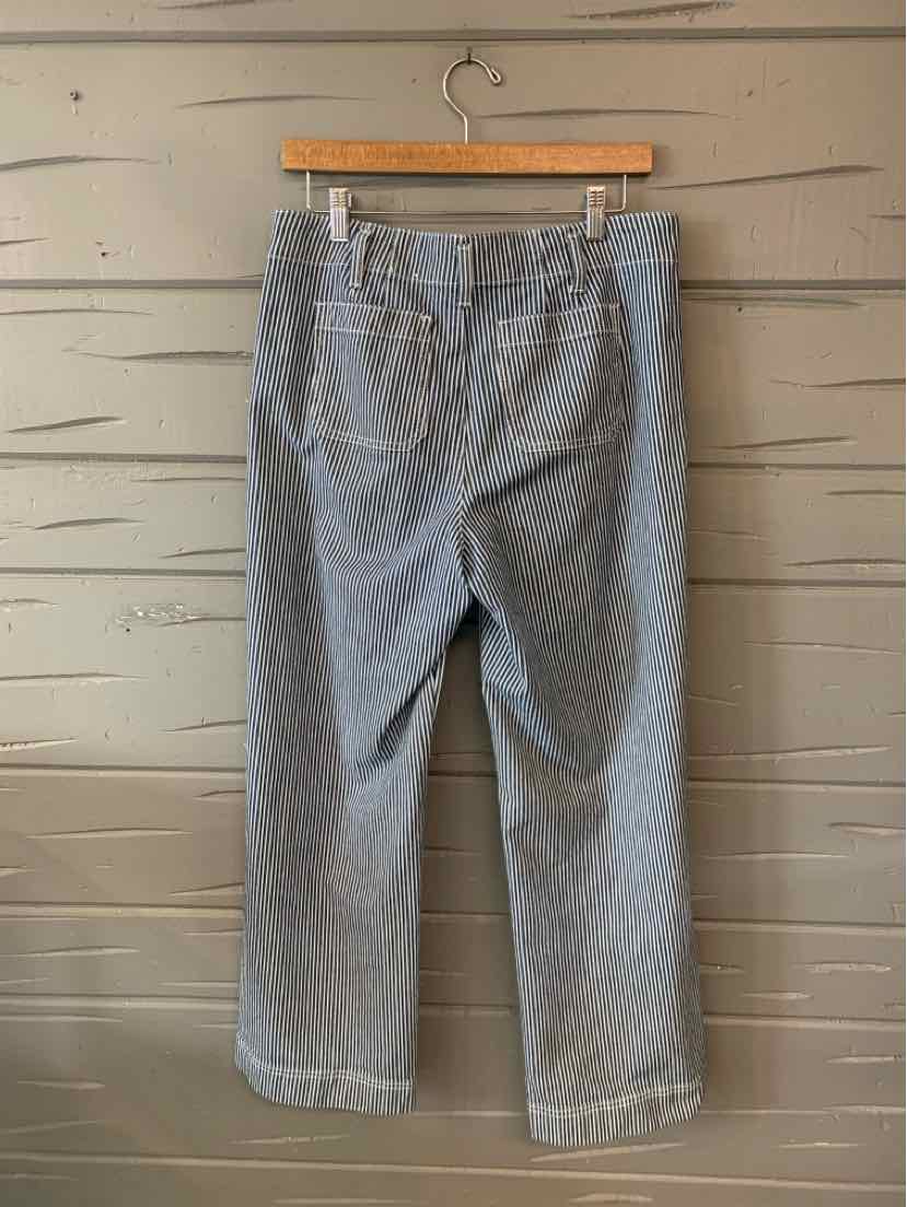Gray and white striped cropped pants with back pockets and a relaxed fit, hanging on wooden hanger.
