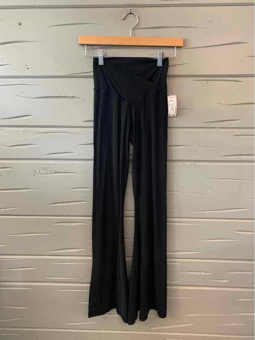 Black high-waisted flare leggings with a smooth, stretchy fabric hanging on wooden hanger.