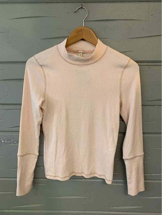 Light pink long-sleeve ribbed knit top with mock neck and fitted silhouette on wooden hanger.