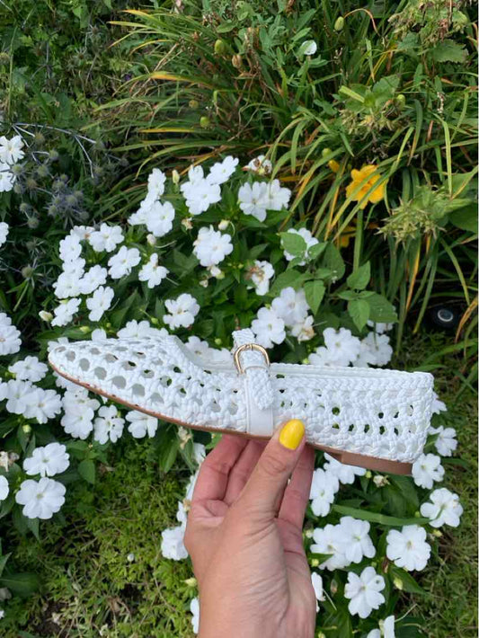 White woven leather flat sandal with adjustable buckle strap and cushioned sole, women's size 6.