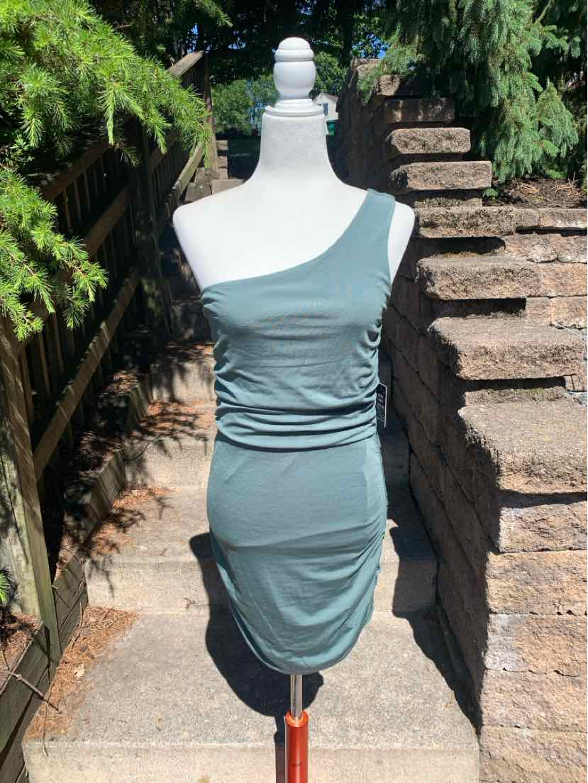 Light blue sleeveless fitted ruched mini dress with square neckline on mannequin outdoors.