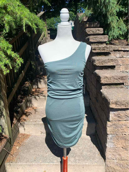 Light blue sleeveless fitted ruched mini dress with square neckline on mannequin outdoors.