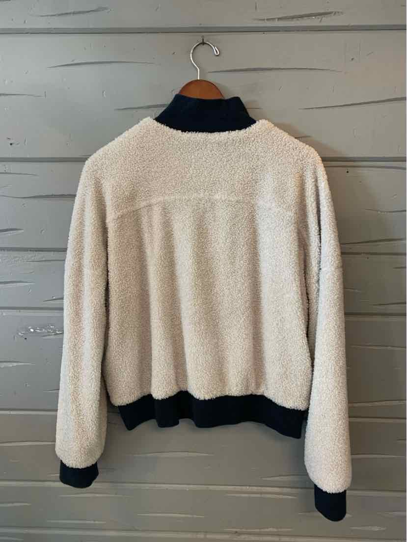Cream sherpa fleece jacket with a black collar, cuffs, and hem, shown from the back.