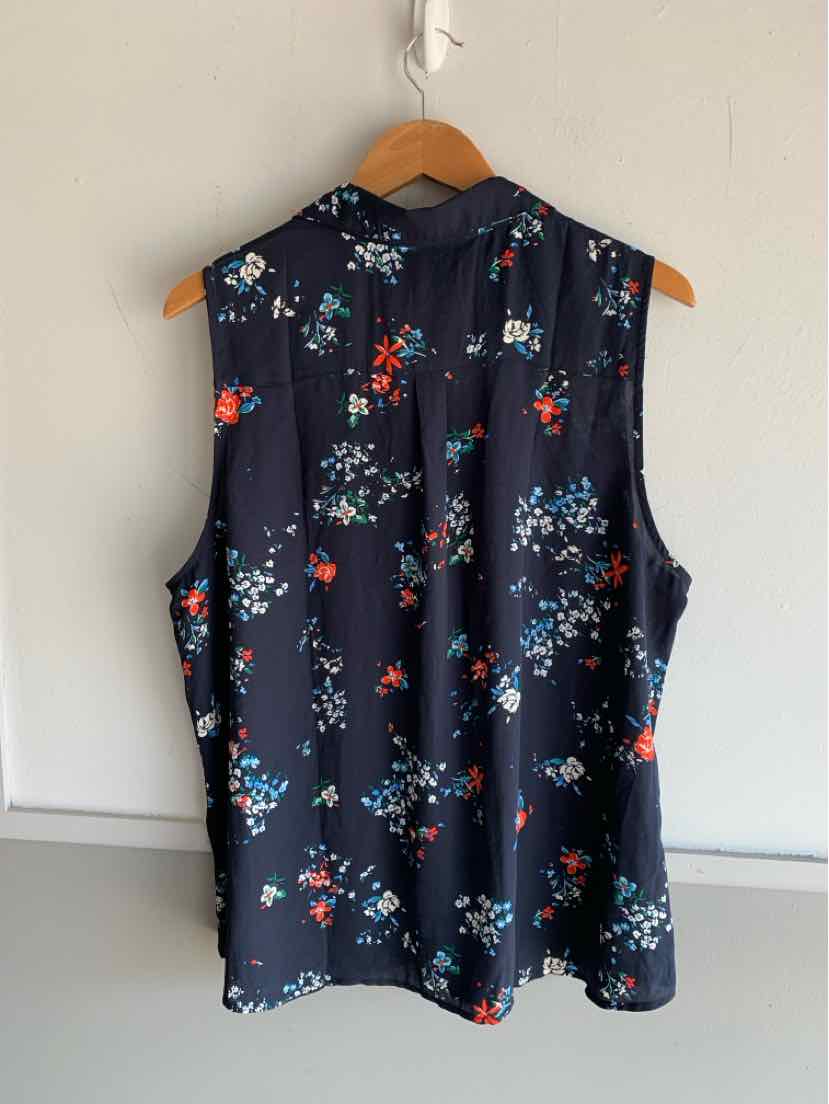 Sleeveless navy blouse with multicolor floral print, button-down back, and relaxed fit.