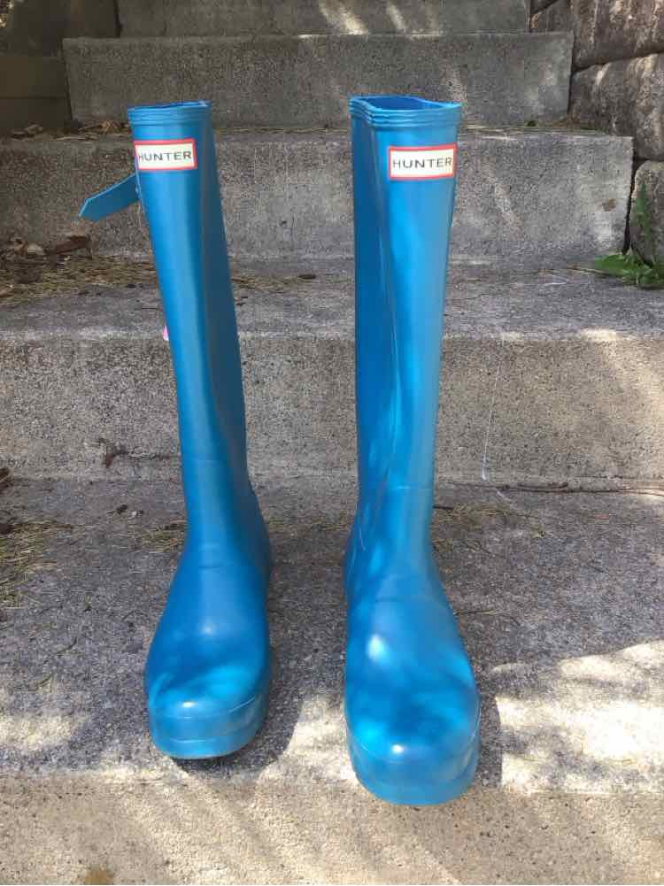 Pair of tall blue rubber Hunter boots size 9 with red and white logo on front shaft.