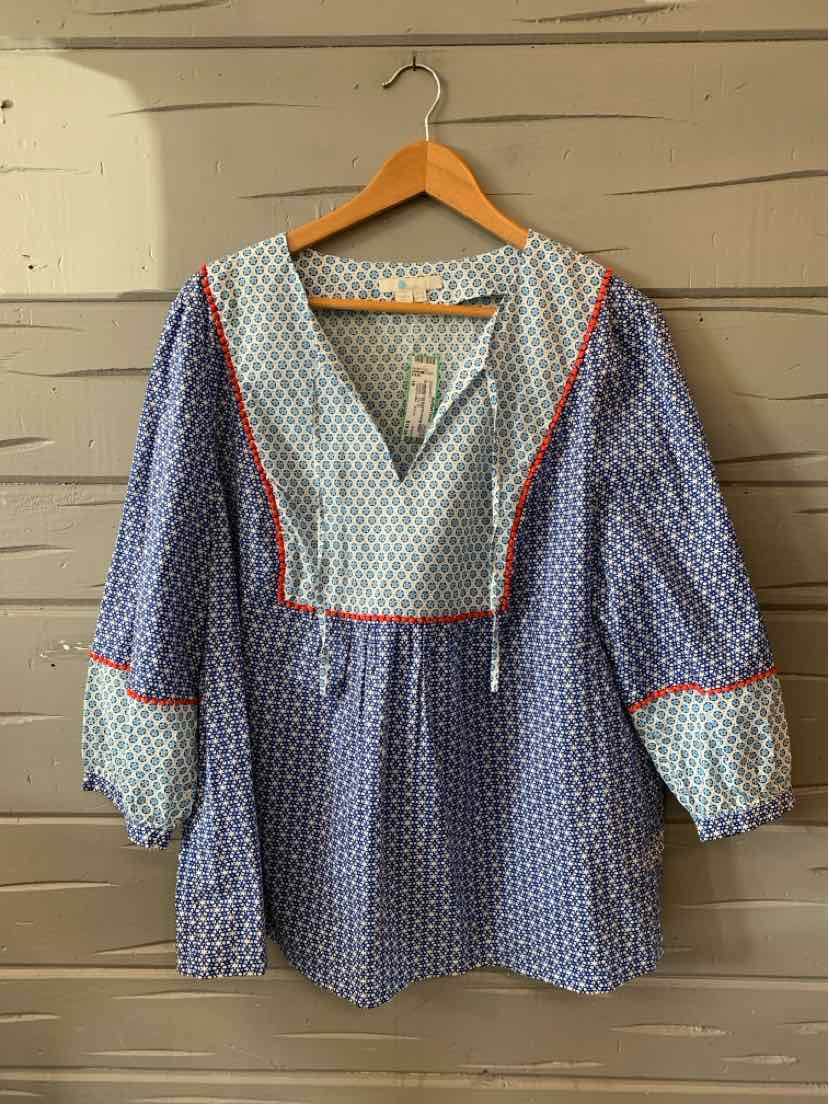 Blue blouse with white polka dots, red piping, V-neck, and puffed sleeves with elastic cuffs.