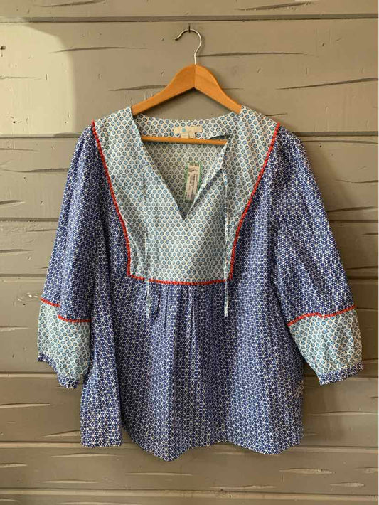 Blue blouse with white polka dots, red piping, V-neck, and puffed sleeves with elastic cuffs.