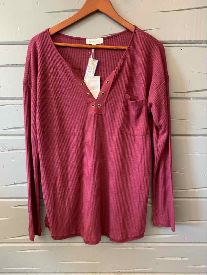 Burgundy long-sleeve women's casual top with V-neck and button details hanging on wooden hanger.