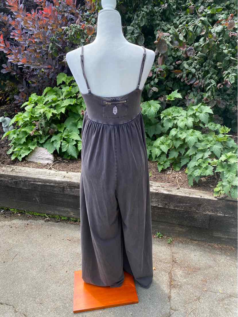 Gray sleeveless jumpsuit with adjustable spaghetti straps and elastic waistband, relaxed wide-leg fit.