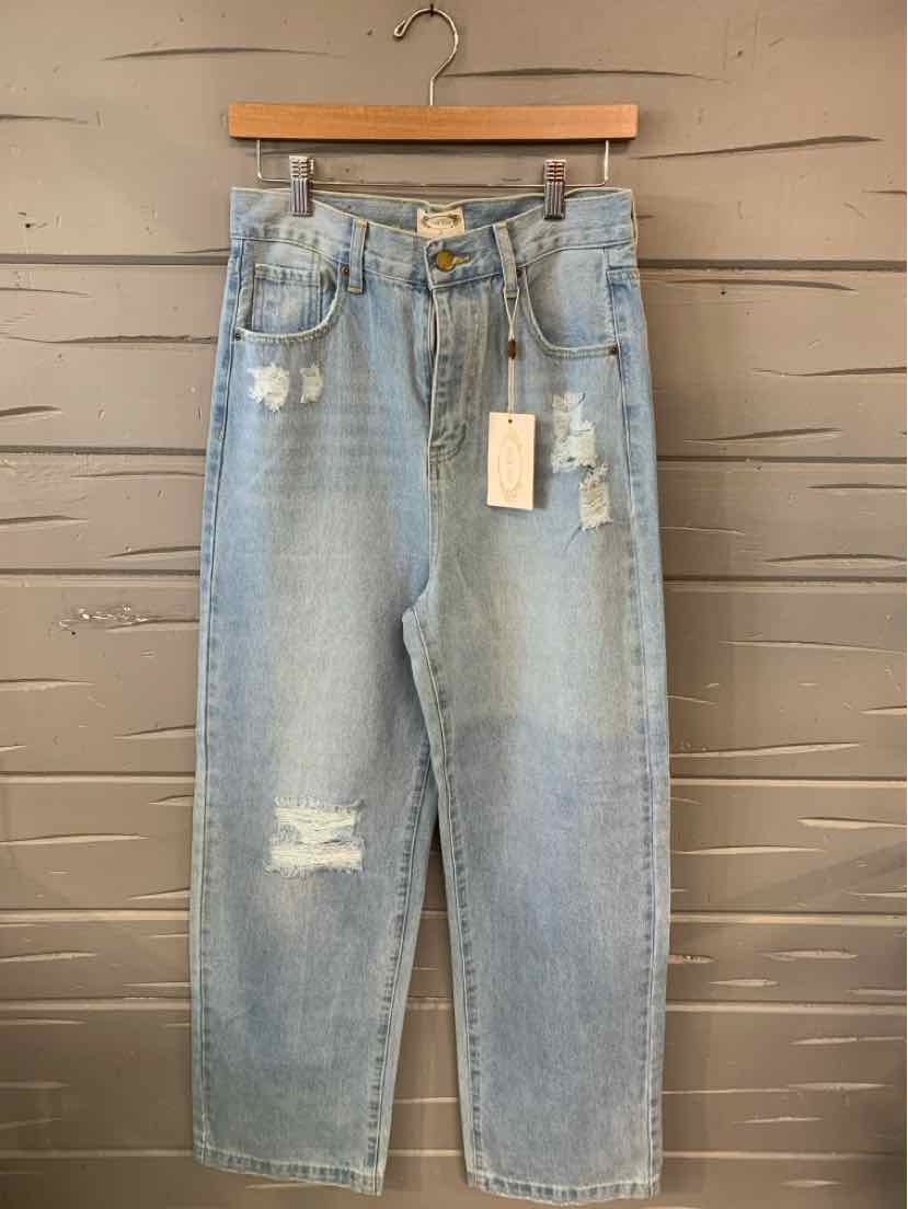Light blue denim jeans with distressed details, high waist, and straight leg cut hanging on wooden hanger.