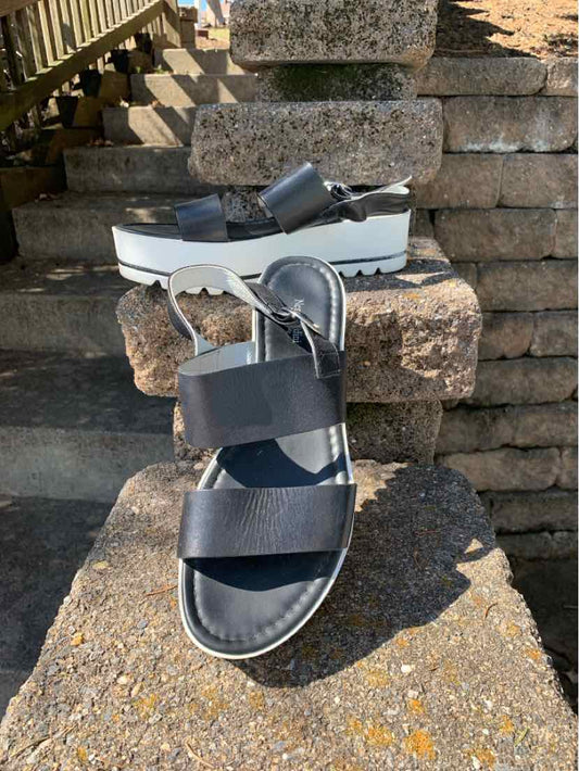 Black platform sandal with wide straps and scalloped white sole, size 40.