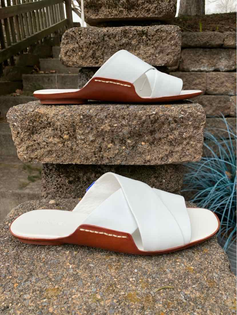 White leather slide sandal with wide crisscross straps and tan sole in size 9.
