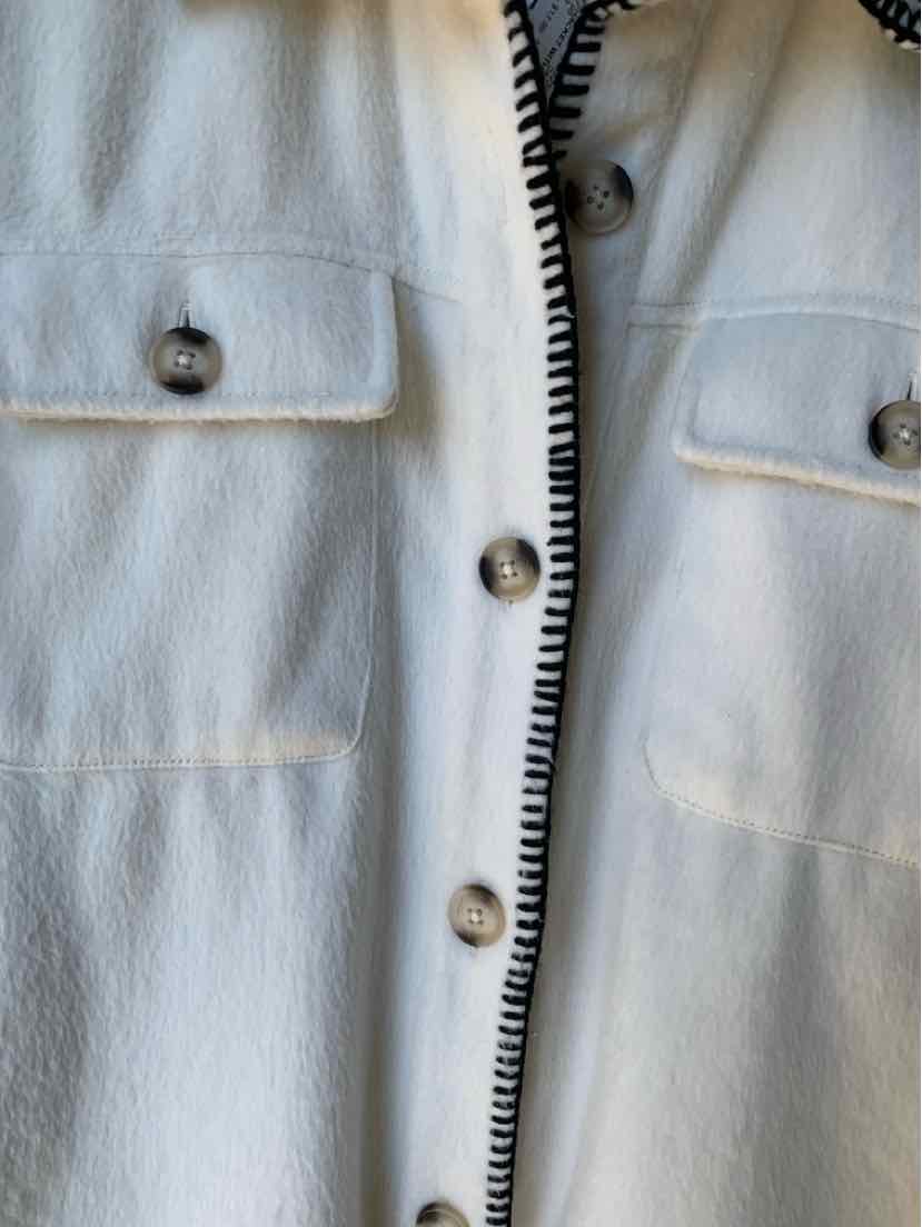 Light gray Maurice’s jacket with a textured finish, flap chest pockets, and black-and-white striped trim.